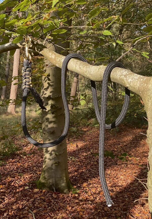 UE Halstertouw Elegant met zwarte basis, gouden accenten en handgemaakte details zoals veren en kralen – perfect te combineren met UE Touwhalster.