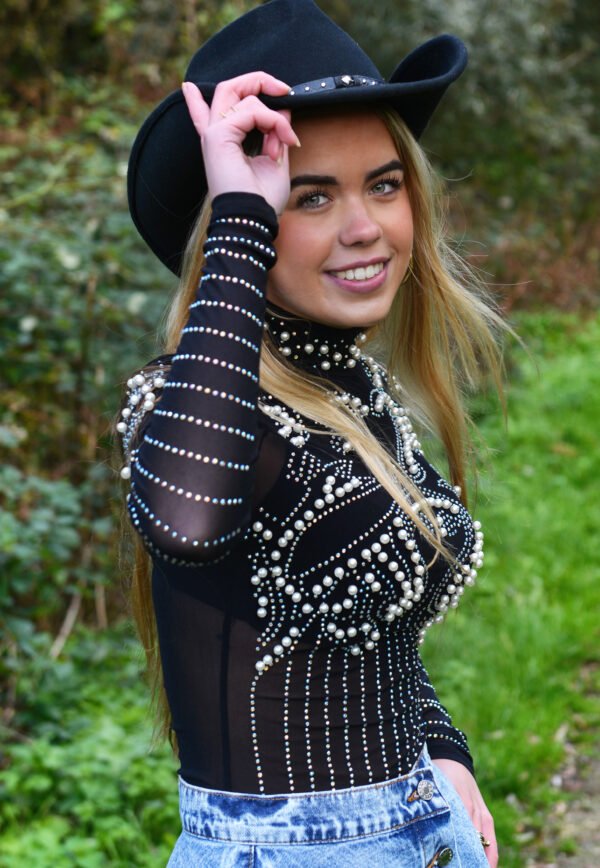 Model draagt de zwarte Rodeo Queen Bodysuit met pareldetails en cowboyhoed.
